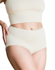 Person wearing a natural undyed organic cotton high rise brief bottom on a white background