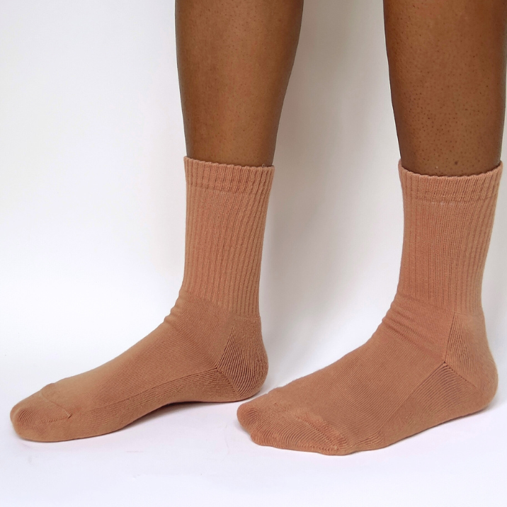 organic pima cotton crew socks ethically and sustainably made in Peru in Maya nude, a warm caramel tone. model is standing with feet slightly apart.