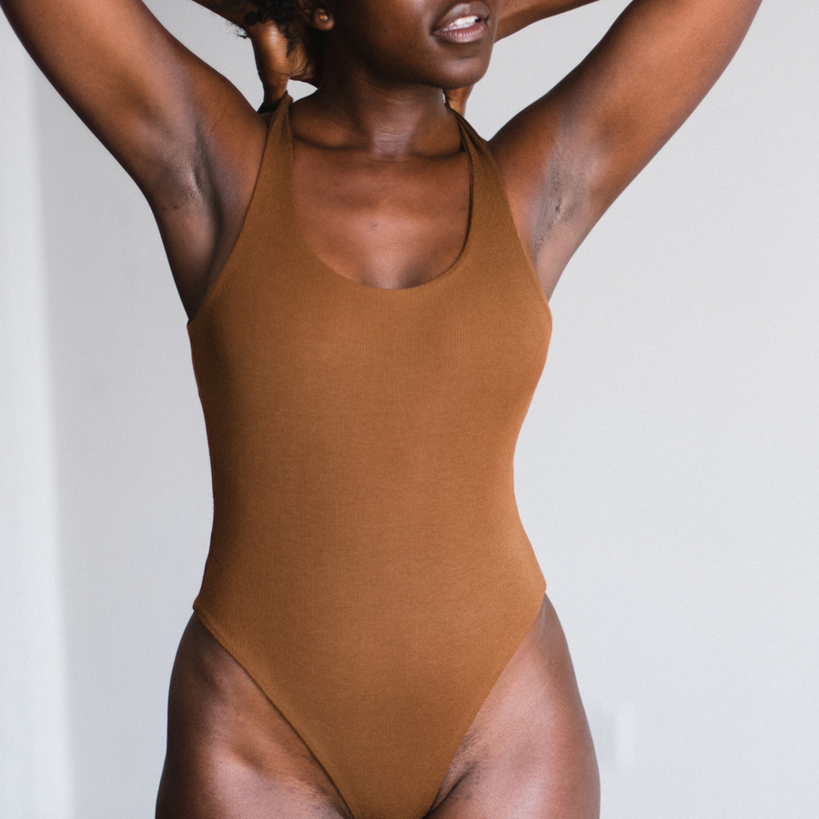 model showing front view of ella nude, brown, bodysuit.  Scoop style, thong bottom.