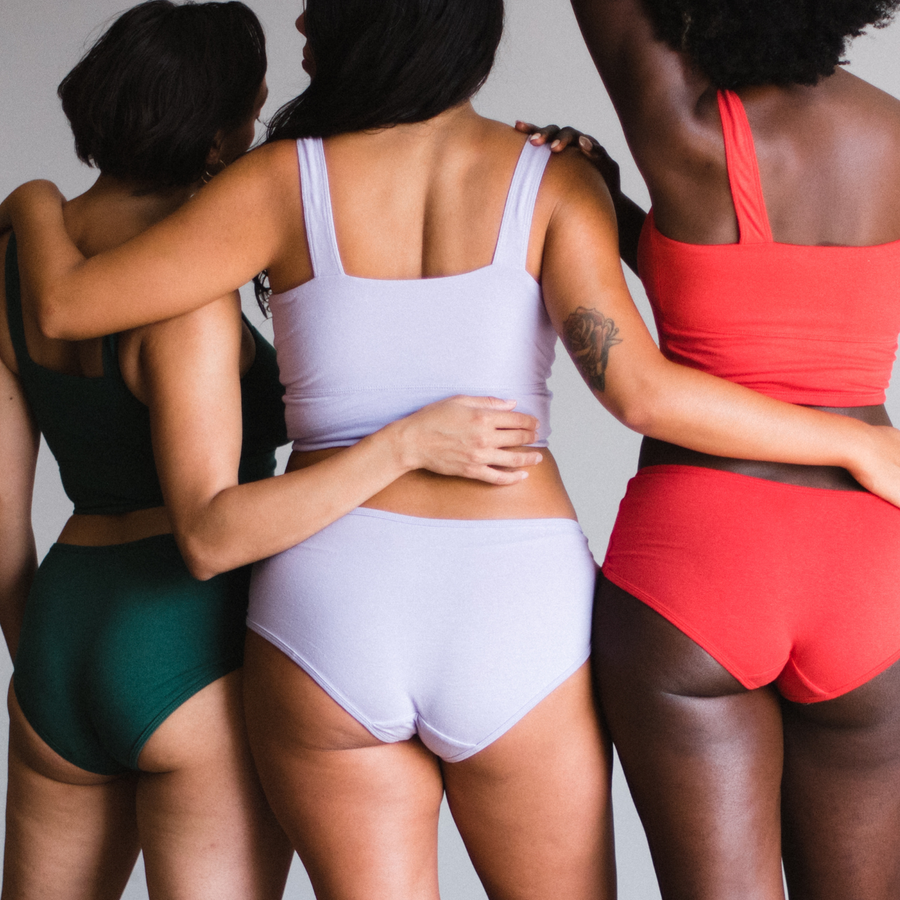 models wearing poppy lagoon green, lilac purple and poppy red mid rise brief and matching square neck top, facing away from camera.