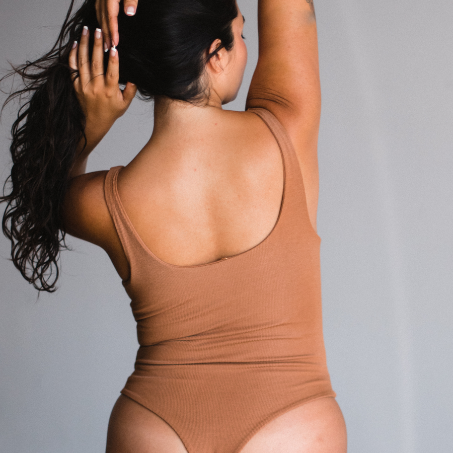 Back view of bodysuit, thong style. Maya nude color, a caramel tone.