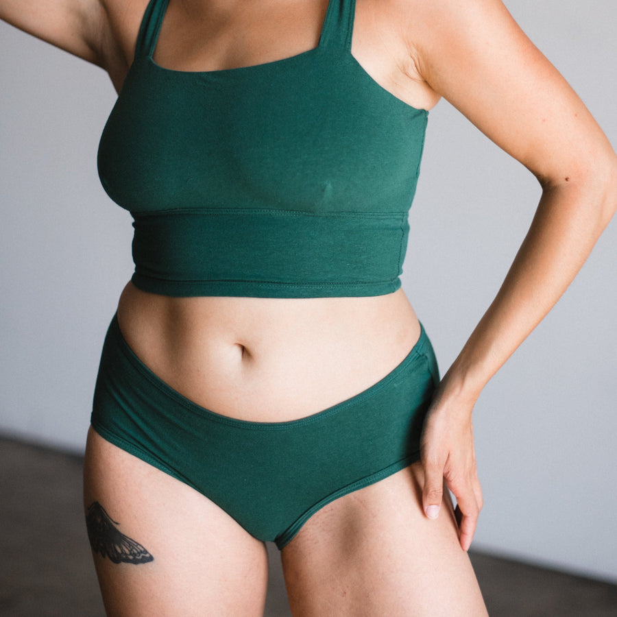 Mid rise brief in lagoon on model, front view. Lagoon is a dark green teal color.