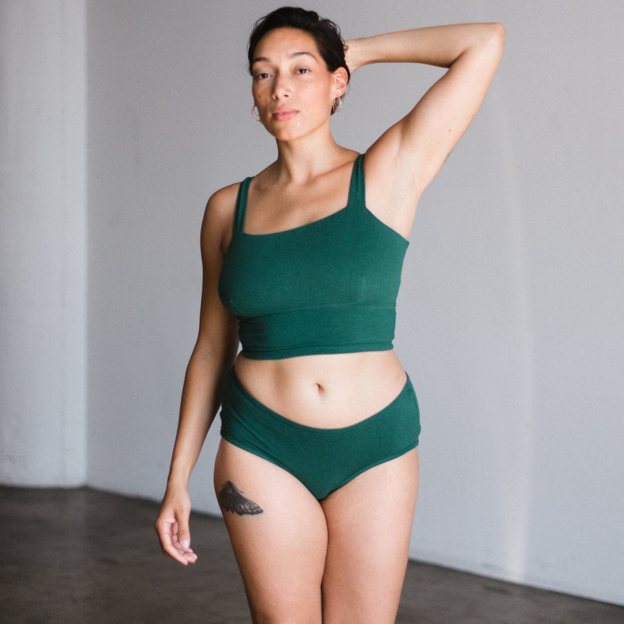 model with hand on head wearing lagoon dark green teal square neck bralette with mid rise briefs